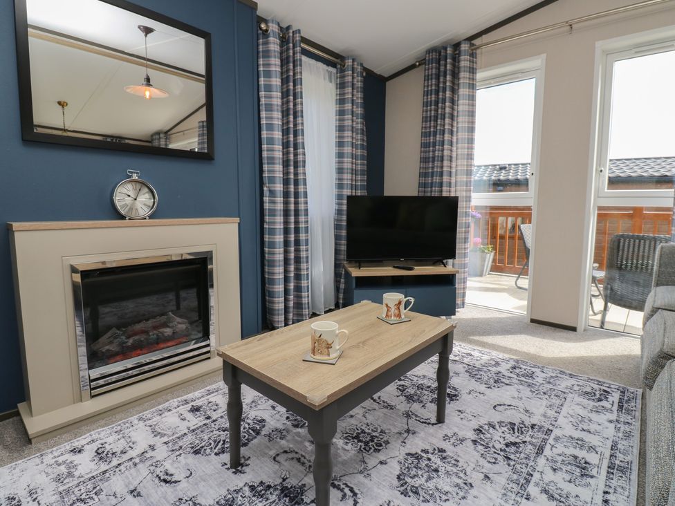 A living room with a fireplace and television at Lodge 52 in Richmond