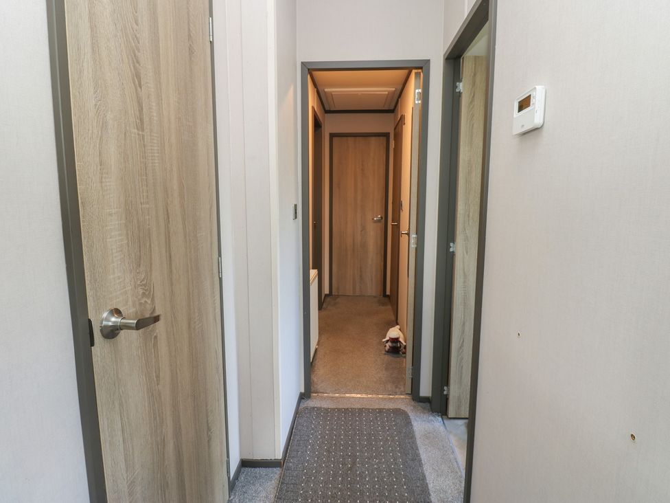 A hallway with doors and a thermostat at Lodge 52 in Richmond