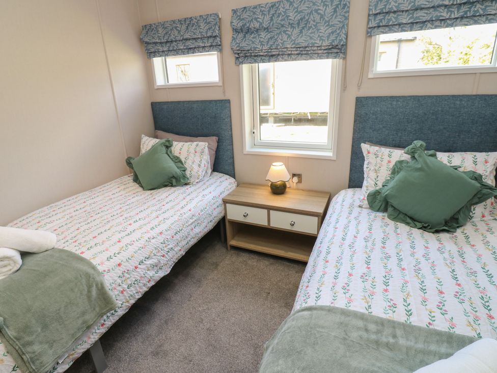 A bedroom with two single beds and a bedside table at Lodge 52 in Richmond