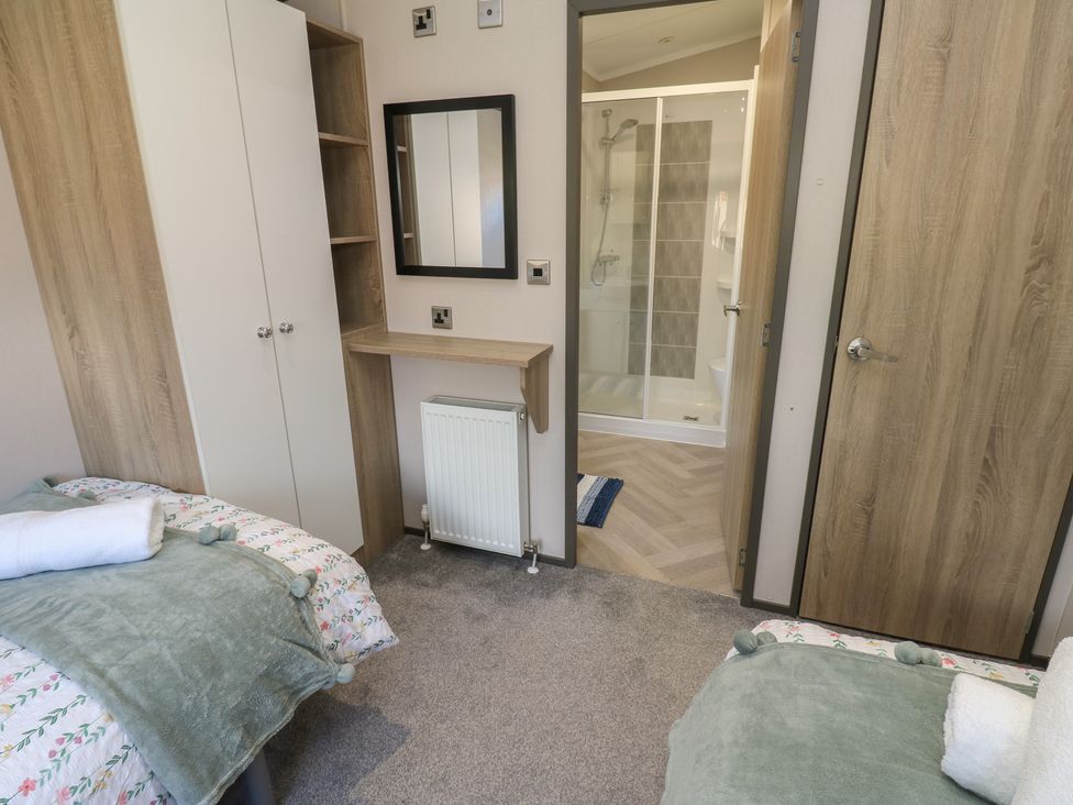 A bedroom with two beds and a bathroom doorway at Lodge 52 in Richmond