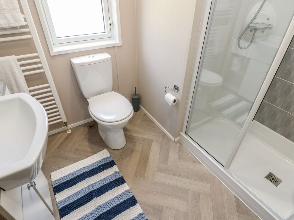 A bathroom with a shower, toilet, and washbasin at Lodge 52 Richmond