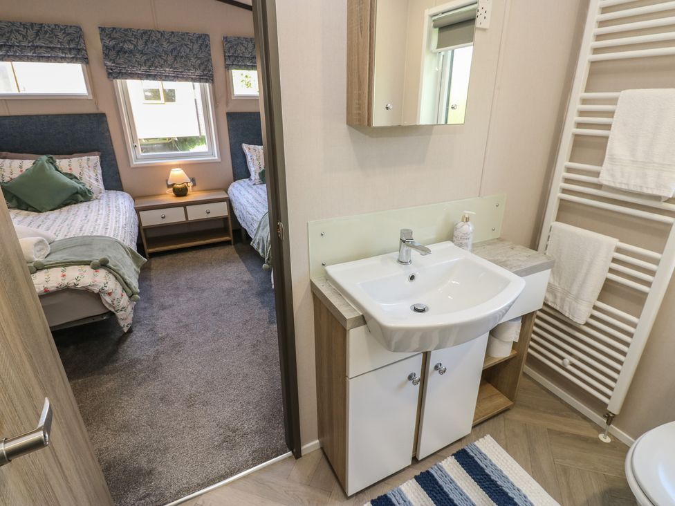 A bathroom with a sink and mirror connected to a bedroom at Lodge 52 in Richmond
