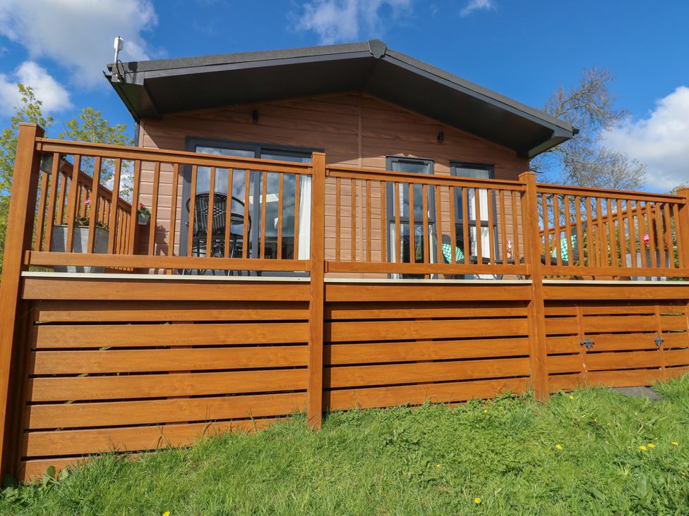 A wooden house with a deck and railing at Lodge 52 in Richmond