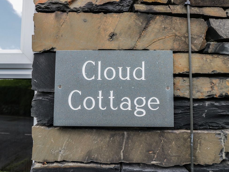 A sign for Cloud Cottage on a stone wall in Ambleside