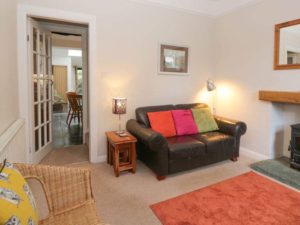 A living room with a sofa and lamp at Cloud Cottage in Ambleside