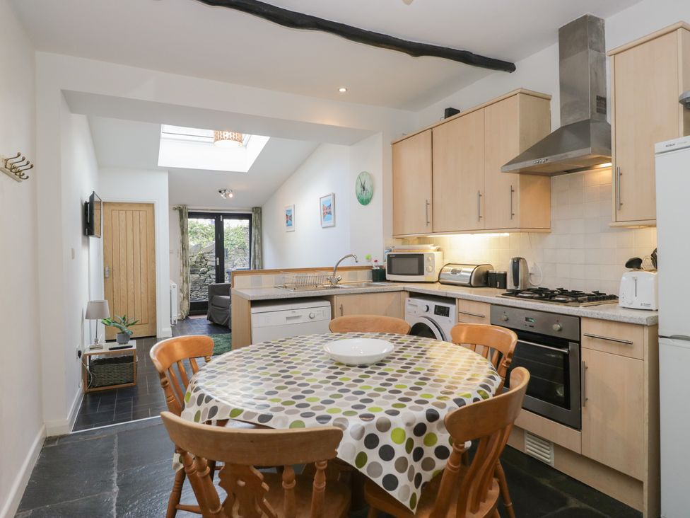 A kitchen with a dining table and appliances at Cloud Cottage in Ambleside