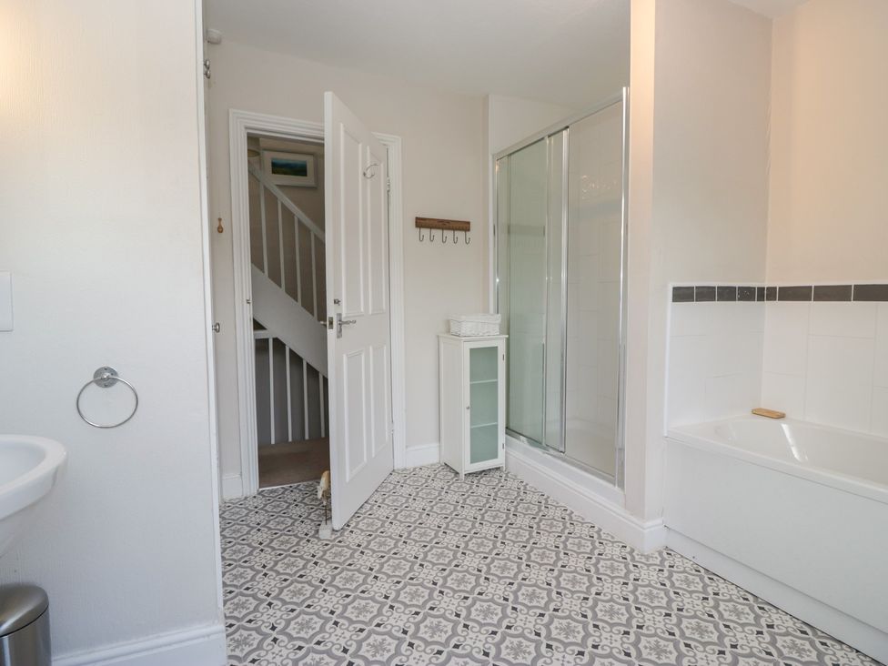 A bathroom with a shower, bathtub, and sink at Cloud Cottage in Ambleside