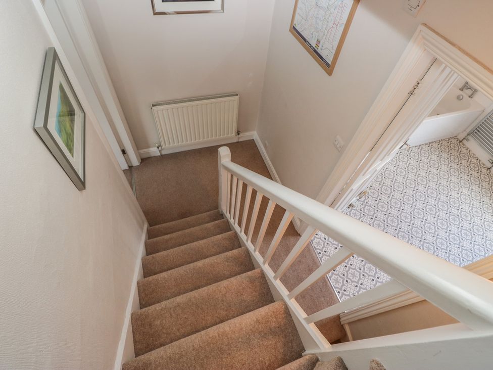 A staircase leading to a bathroom with patterned floor tiles at Cloud Cottage in Ambleside