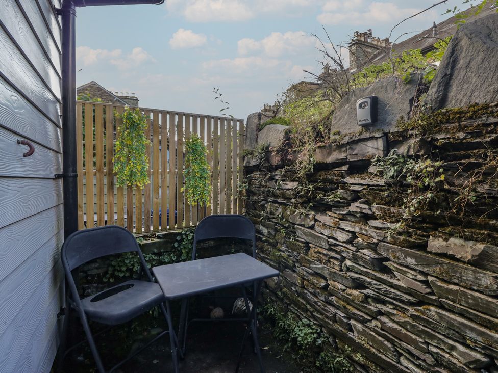 An outdoor seating area with a table and chairs at Cloud Cottage in Ambleside