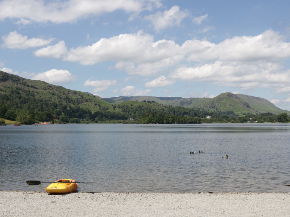 A kayak on a lake with ducks swimming at Cloud Cottage in Ambleside