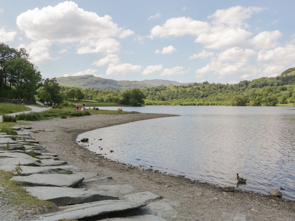 A lake with a stone path and trees at Cloud Cottage, Ambleside