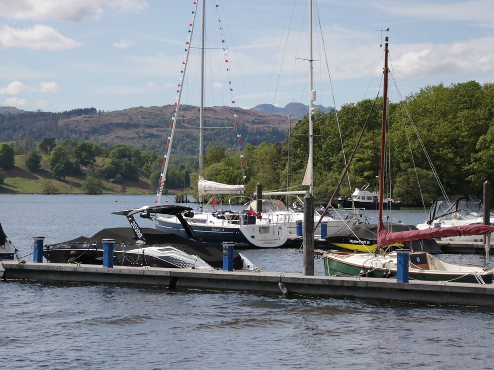 Boats on a dock in a lake with mountains in the background at Cloud Cottage Ambleside