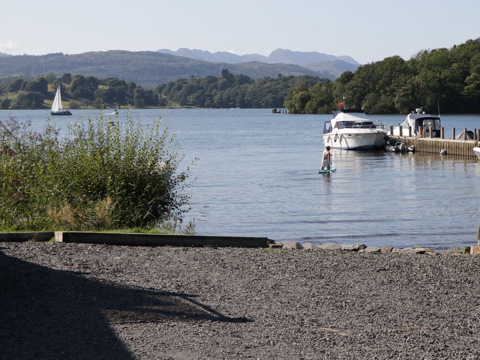 A view of a lake with boats and a paddleboarder at Cloud Cottage in Ambleside