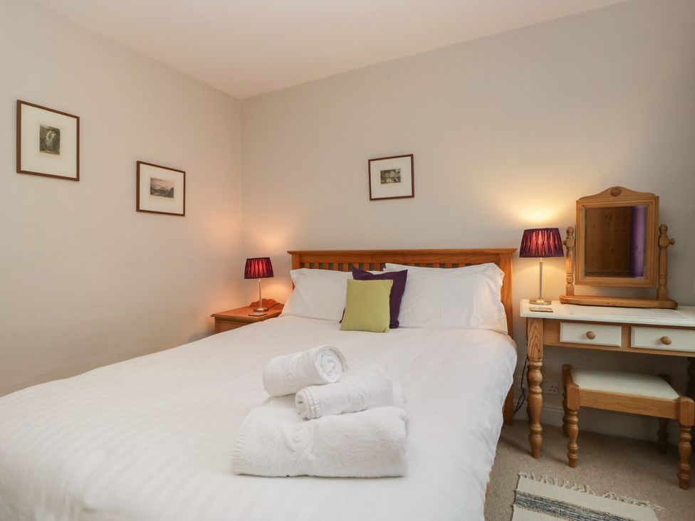 A bedroom with a bed and lamp at Cloud Cottage in Ambleside