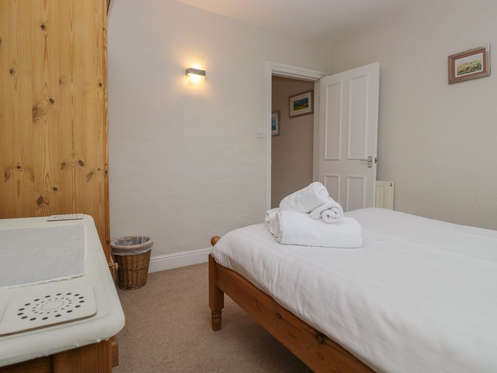 A bedroom with a bed and towels at Cloud Cottage in Ambleside
