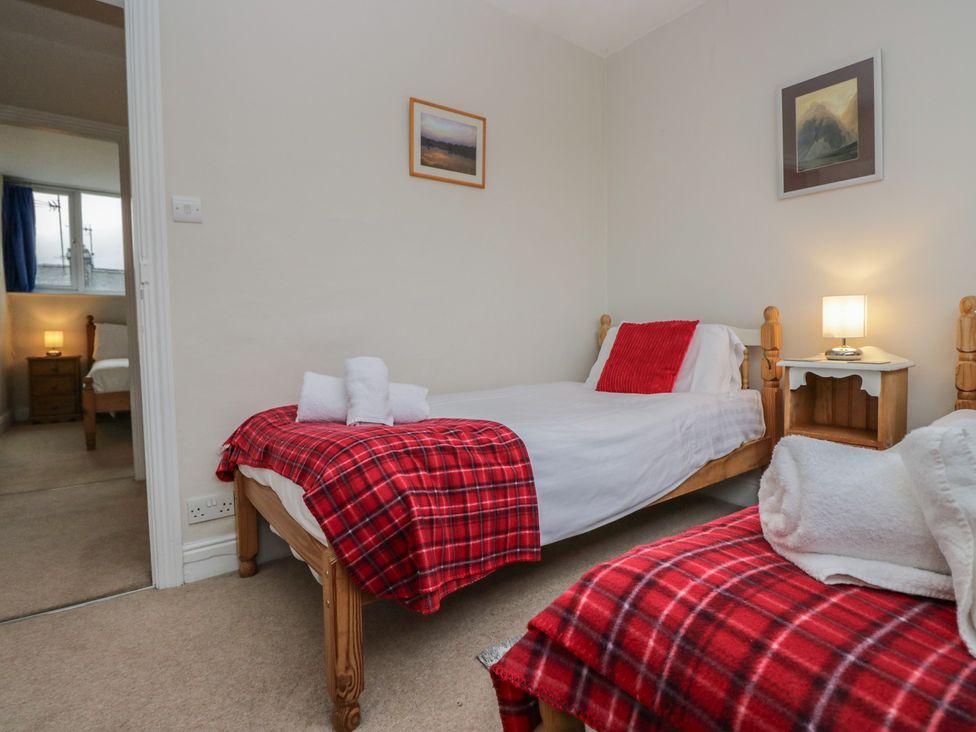 A bedroom with two beds and a lamp at Cloud Cottage in Ambleside