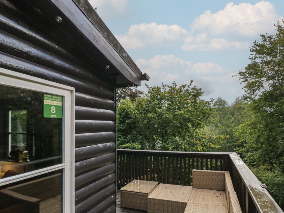 An outdoor area with a deck and sofa at Moon Cottage White Cross Bay Holiday Park near Troutbeck Bridge
