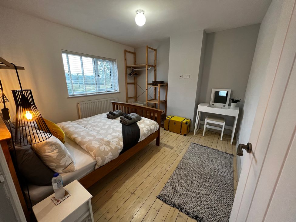 A bedroom with a bed and desk at Dolwen in Caernarfon