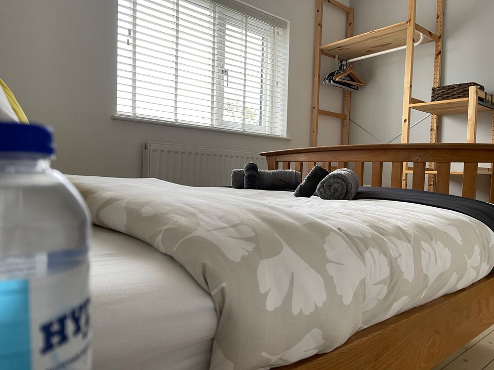 A bedroom with a bed and a shelf at Dolwen in Caernarfon