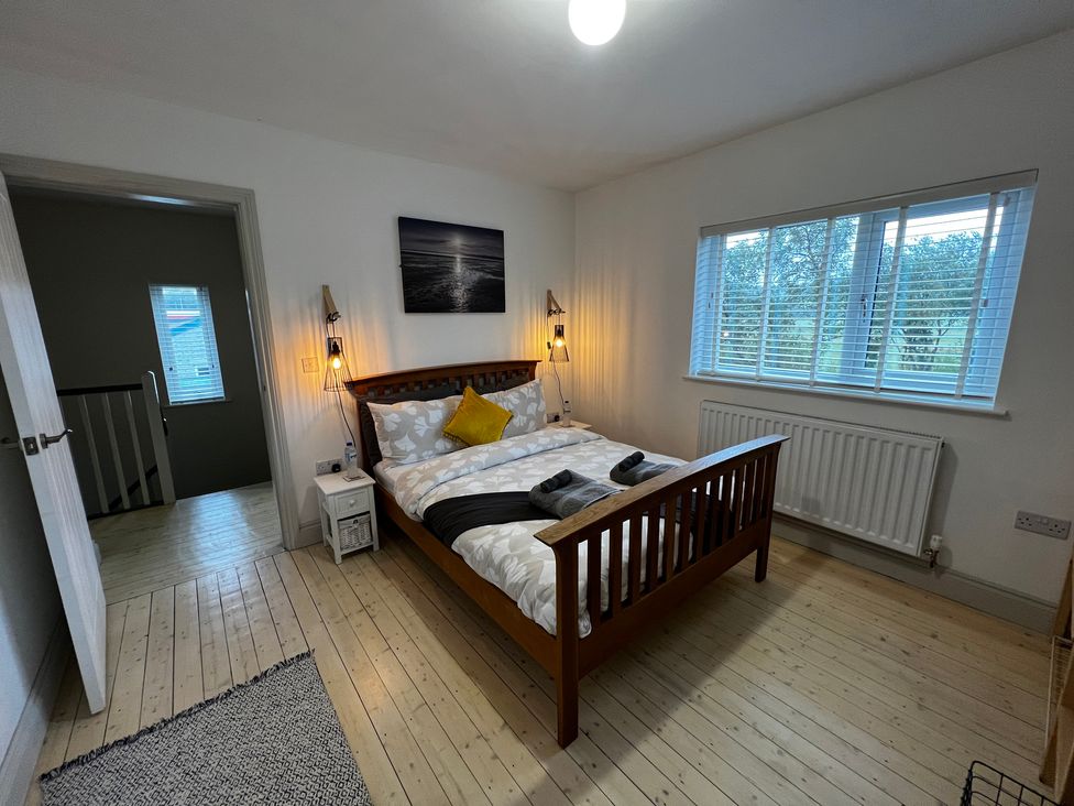 A bedroom with a bed and bedside table at Dolwen in Caernarfon