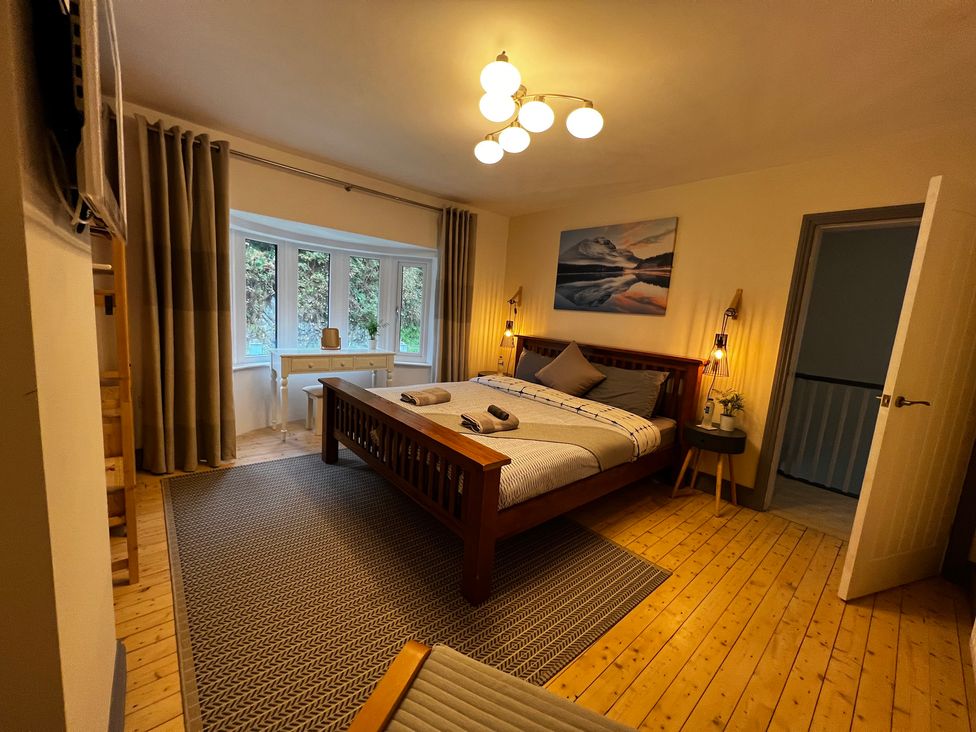 A bedroom with a bed and window at Dolwen in Caernarfon