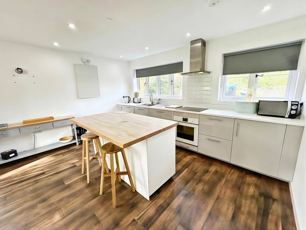 A kitchen with appliances and a dining area at Hen Stablau in Corwen