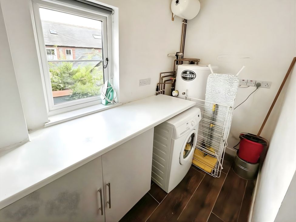 A utility room with a washing machine and a drying rack at Hen Stablau in Corwen