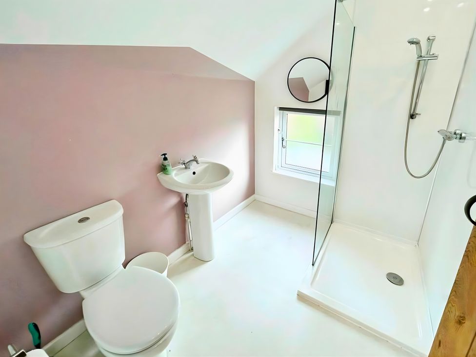 A bathroom with a toilet, sink, and shower at Hen Stablau in Corwen