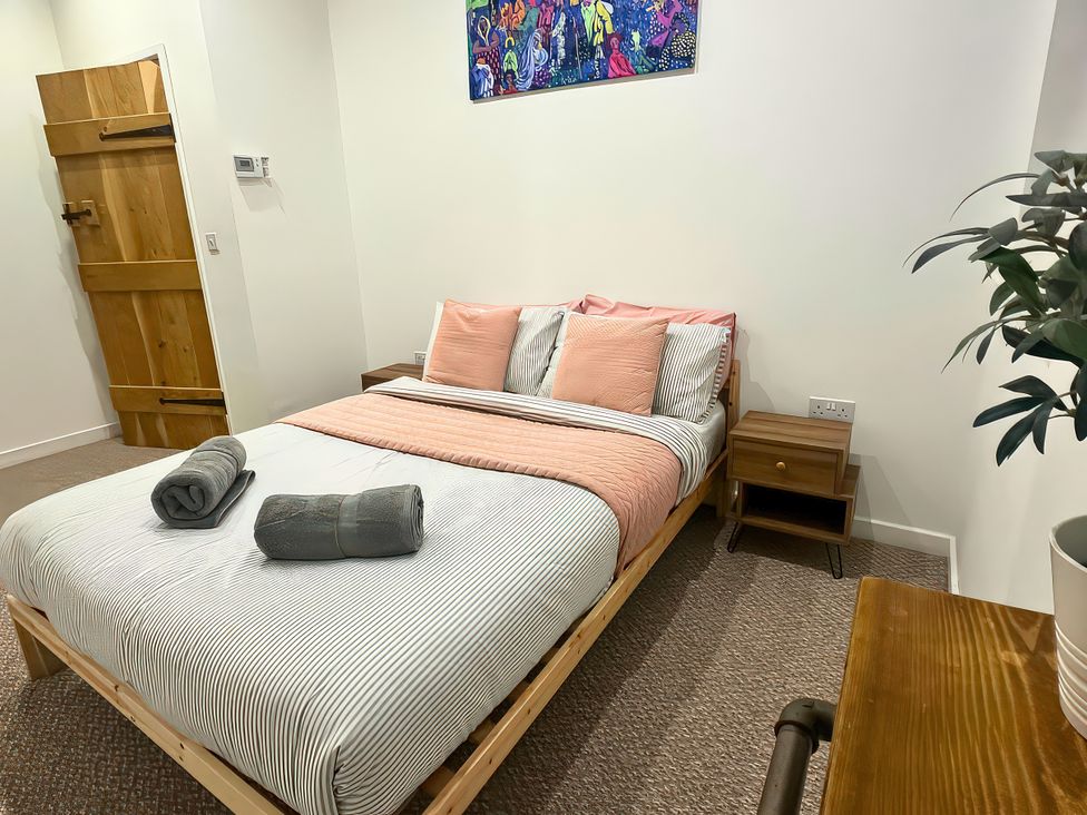 A bedroom with a bed, nightstand and towels at Hen Stablau Dinmael near Cerrigydrudion