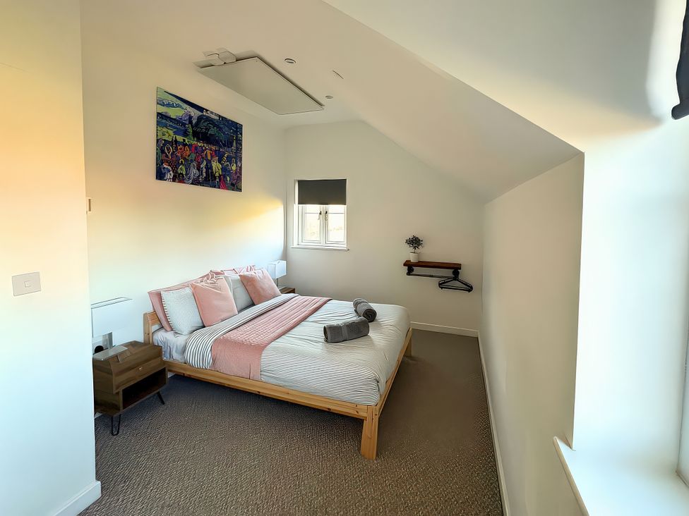A bedroom with a bed and artwork at Hen Stablau in Dinmael near Cerrigydrudion