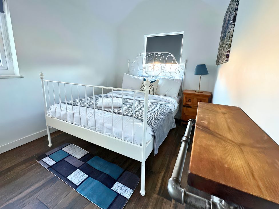 A bedroom with a bed and bedside table at Hen Stablau Dinmael near Cerrigydrudion