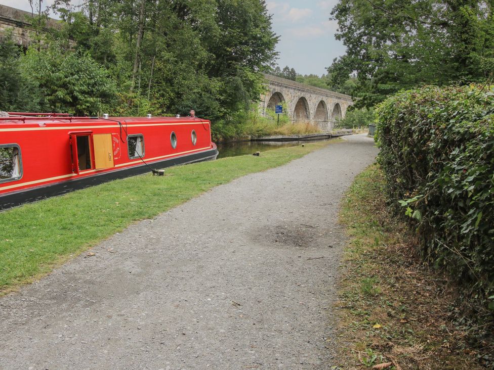 A narrowboat along a pathway near a stone bridge at Pentre Country Studio near Chirk