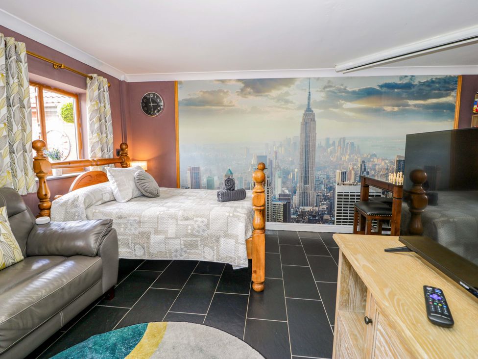 A snug with a bed and sofa at Pentre Country Studio near Chirk