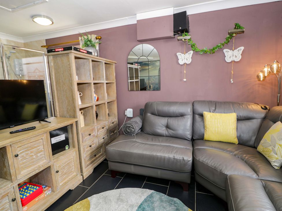 A living room with a sofa and television at Pentre Country Studio near Chirk