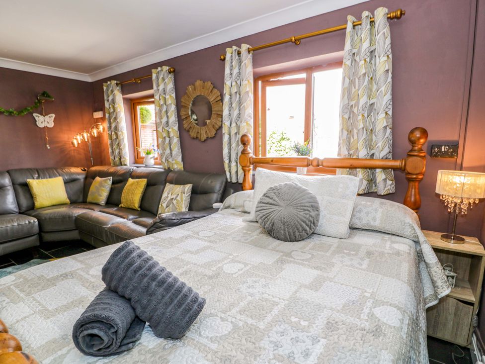 A living room with a bed and sofa at Pentre Country Studio near Chirk