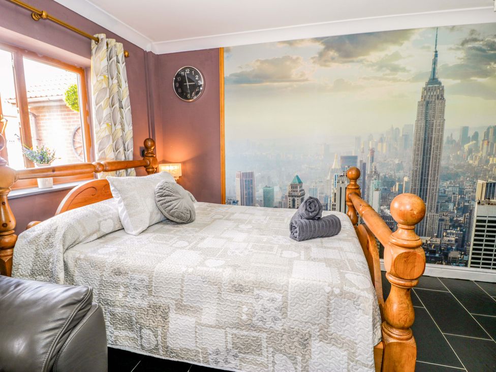 A bedroom with a bed and wall mural at Pentre Country Studio near Chirk