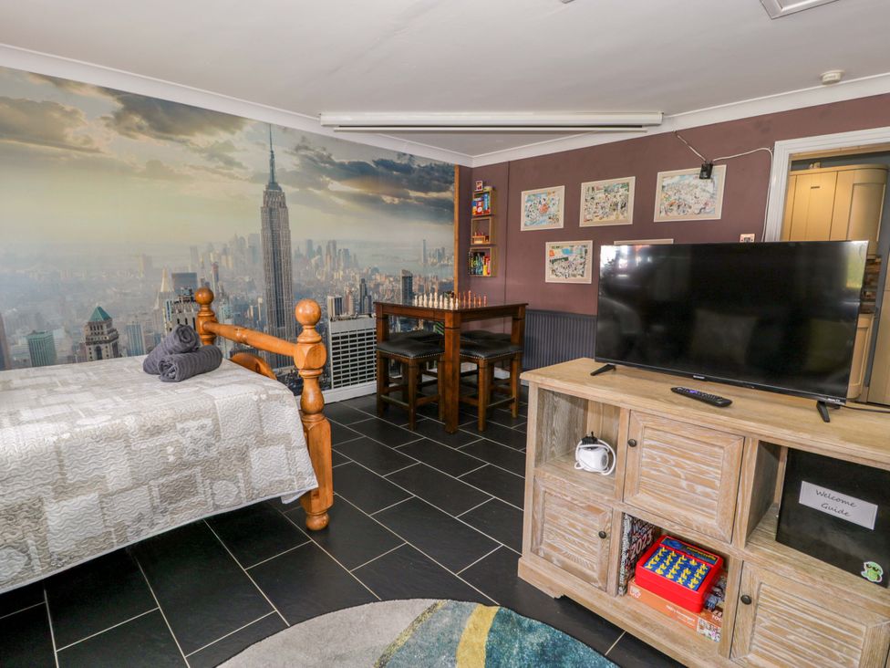 A studio with a bed, table, chairs and television at Pentre Country Studio near Chirk