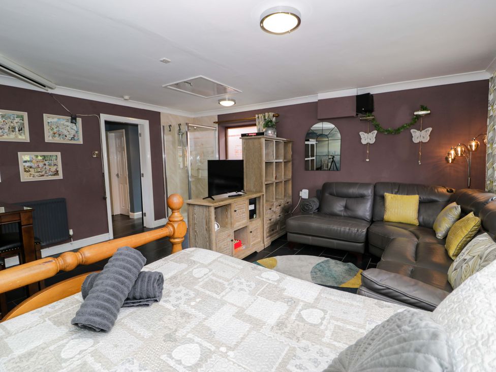 A living room with a sofa and television at Pentre Country Studio near Chirk
