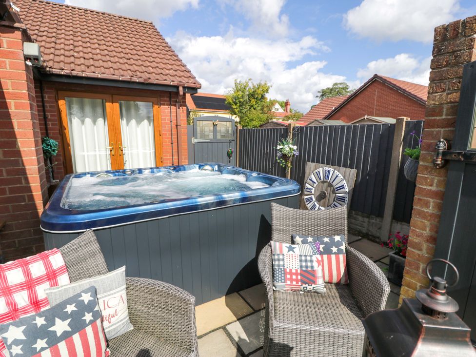 An outdoor area with a hot tub and seating at Pentre Country Studio near Chirk