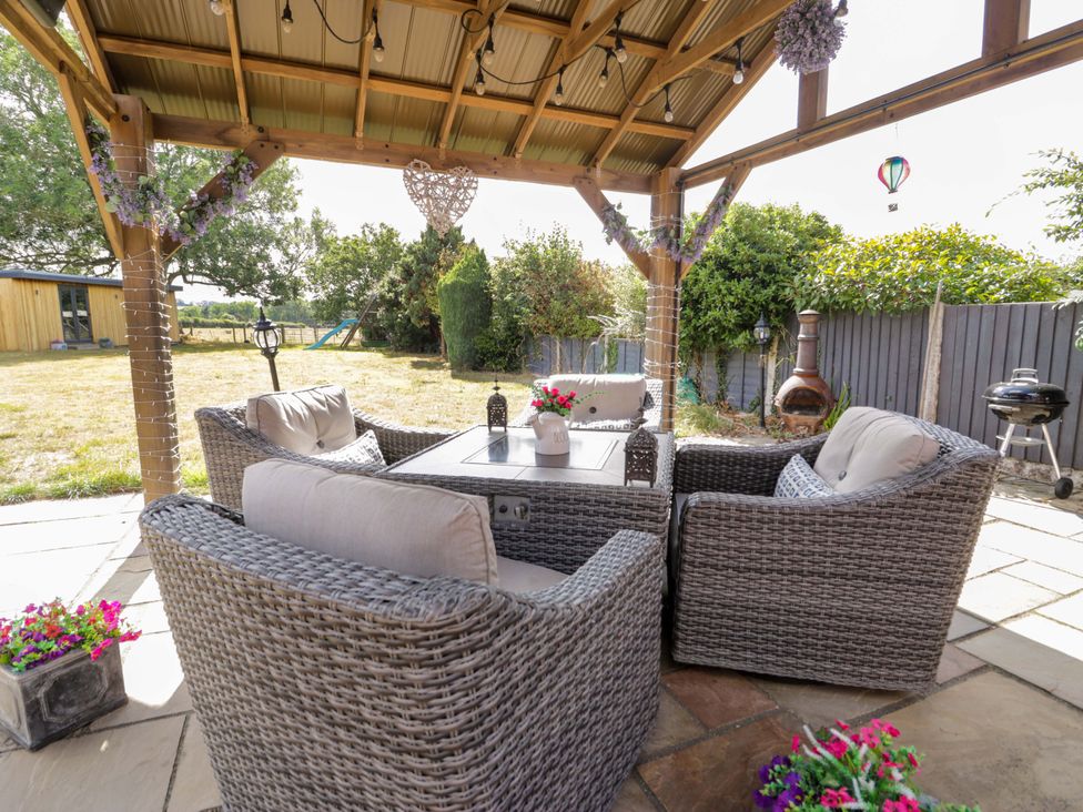 An outdoor seating area with a coffee table and lanterns at Pentre Country Studio near Chirk