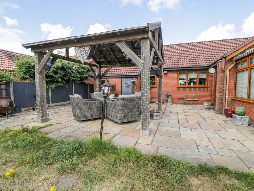 A garden with a pergola and outdoor seating area at Pentre Country Studio near Chirk