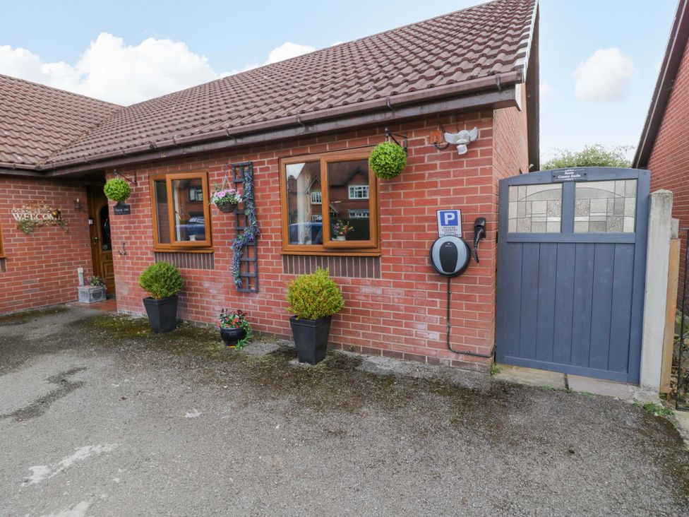 An outdoor view of a house with windows, a door and planters at Pentre Country Studio near Chirk