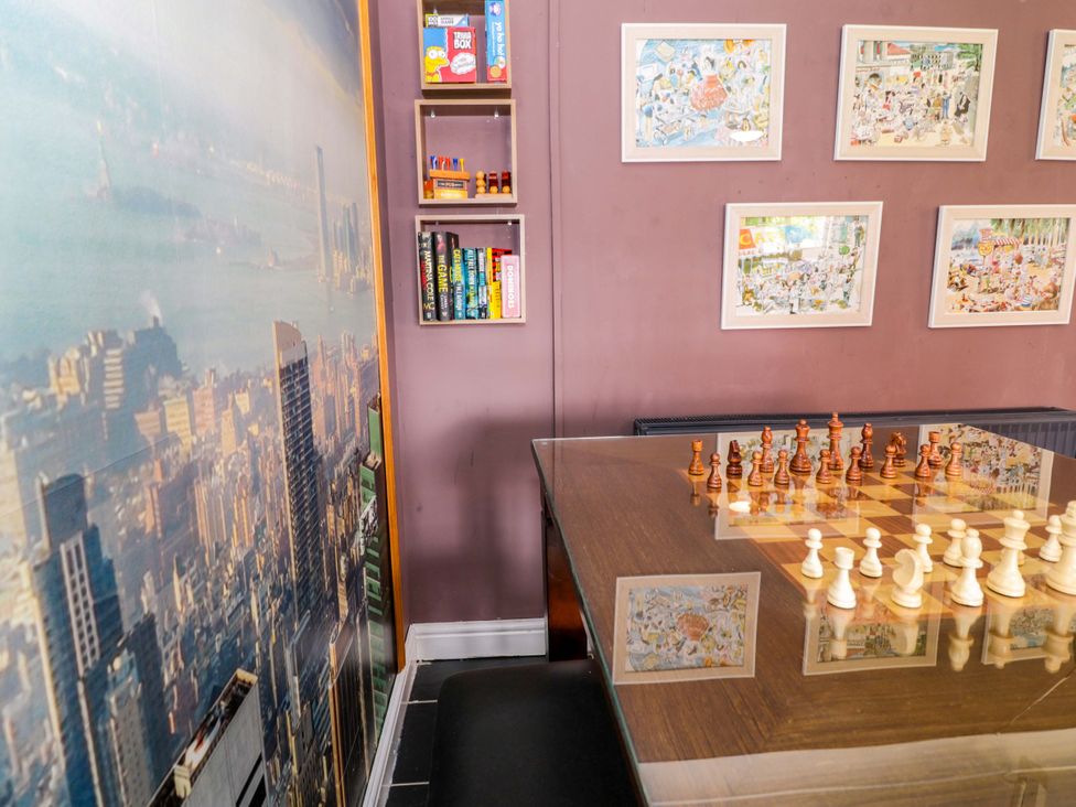 A game room with a chess set and shelves with books at Pentre Country Studio near Chirk