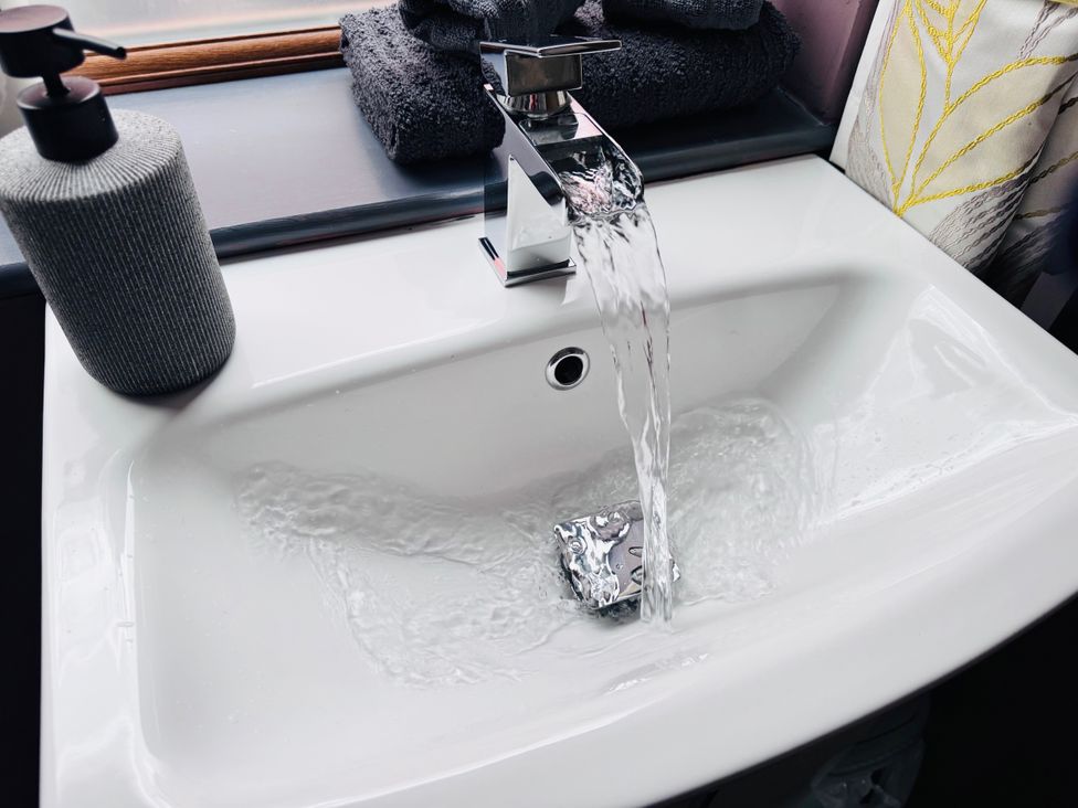 A sink with running water and a soap dispenser at Pentre Country Studio near Chirk