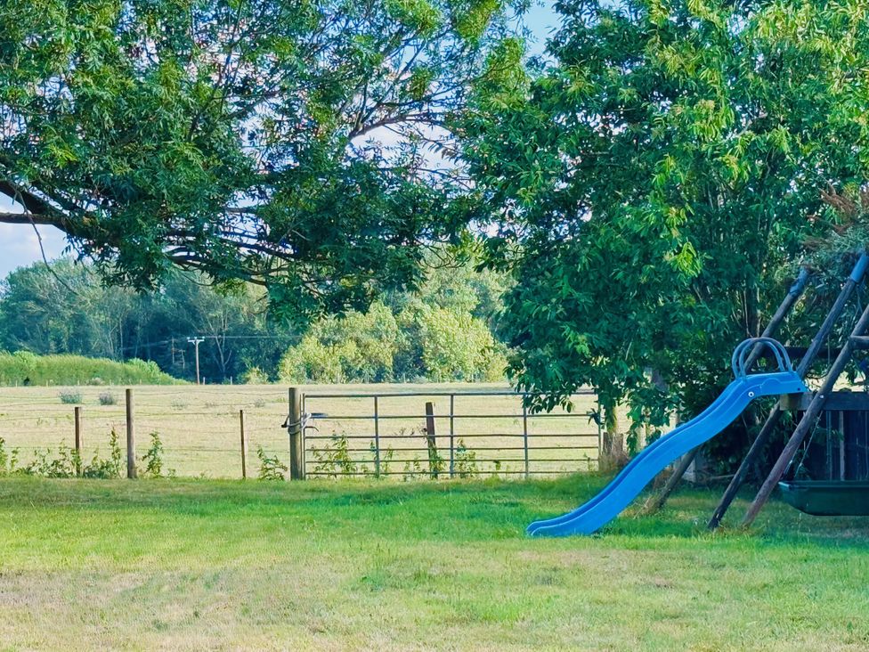 A swing set and slide in a grassy area at Pentre Country Studio near Chirk