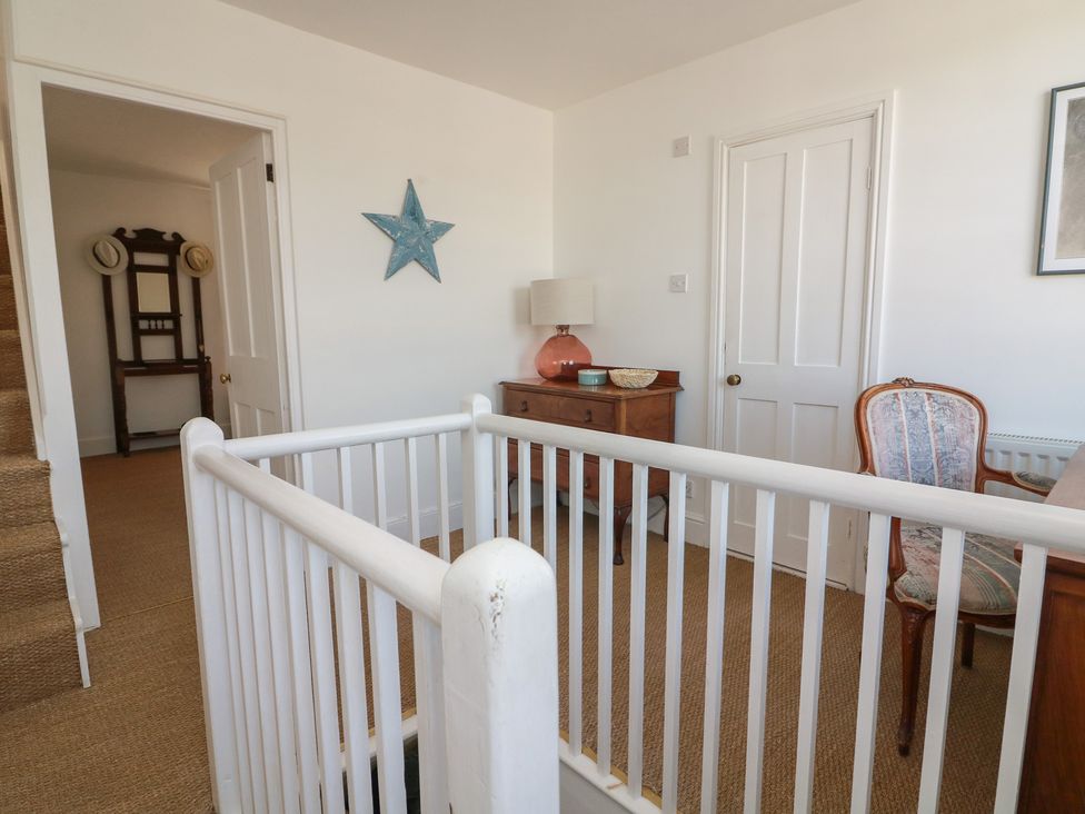 A landing area with a chair and table at 36 Crowthers Hill in Dartmouth