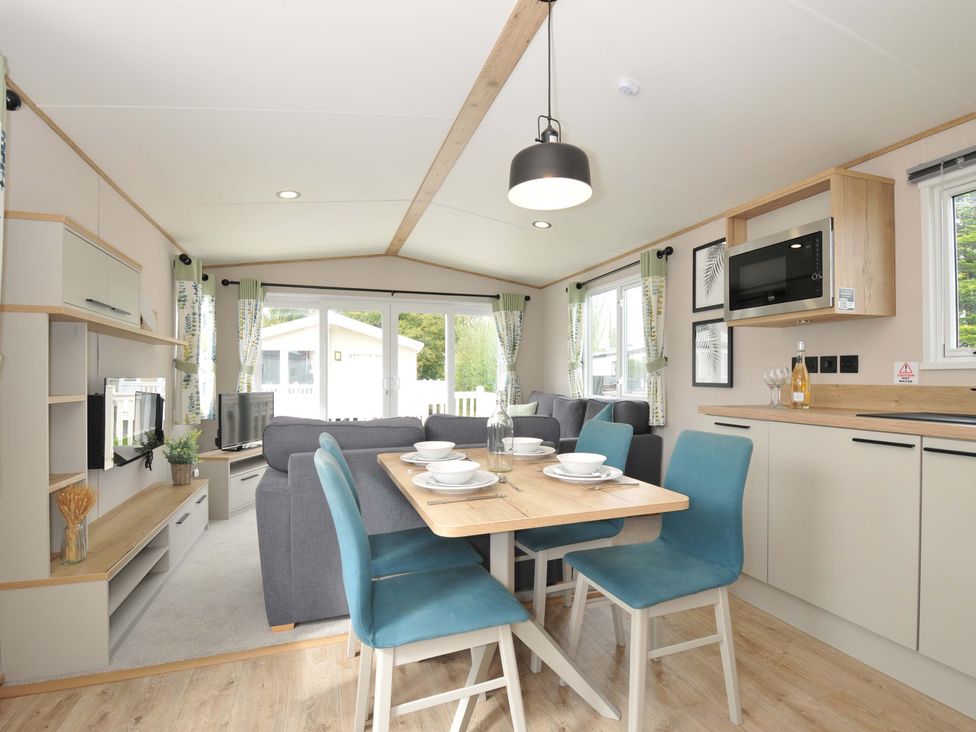 A dining area with a table and chairs at Eden Way 47
