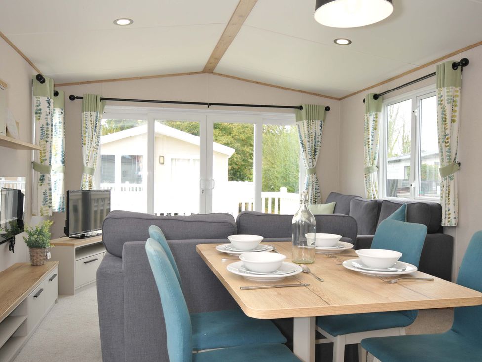 A living room with a dining area and a television at Eden Way 47
