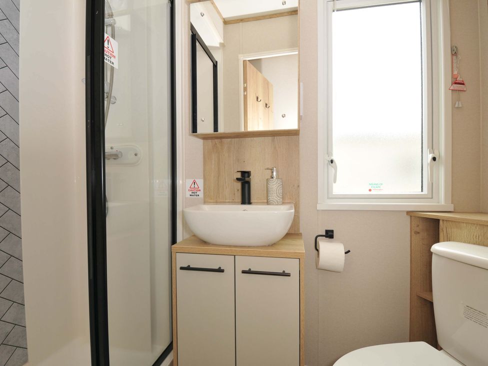 A bathroom with shower, sink, toilet, and mirror at Eden Way 47