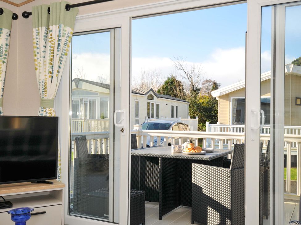 A living room with glass doors leading to an outdoor area at Eden Way 47 Par